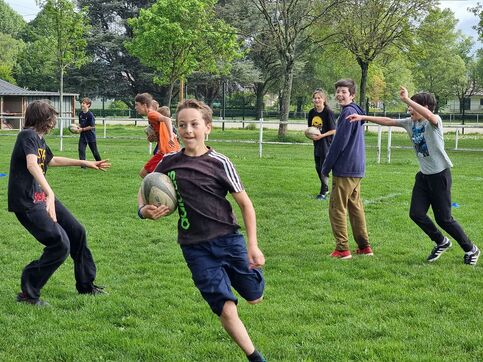 Personnes jeunes en train de jouer au rugby sur un terrain